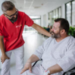 Man being cared for by a private Asian nurse at home suffering f