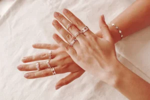 2 hands are showing which are worn multiple diamond rings