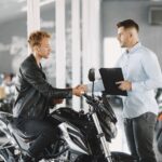 man-choosed-motorcycles-moto-shop-guy-black-jacket-manager-with-client_1157-43592