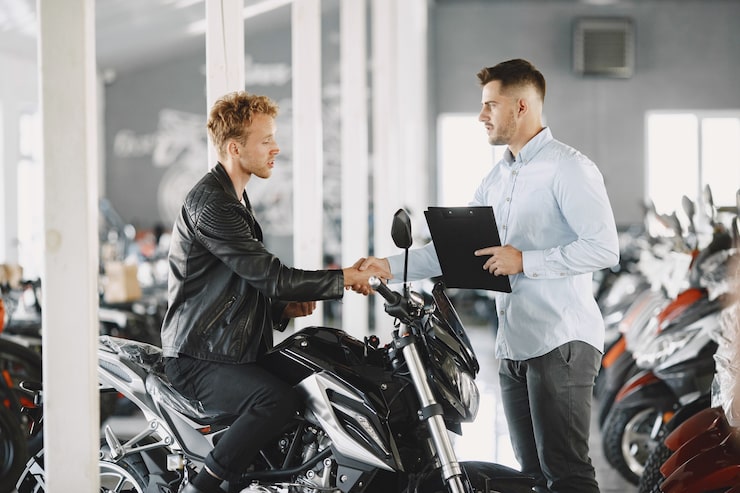 man-choosed-motorcycles-moto-shop-guy-black-jacket-manager-with-client_1157-43592