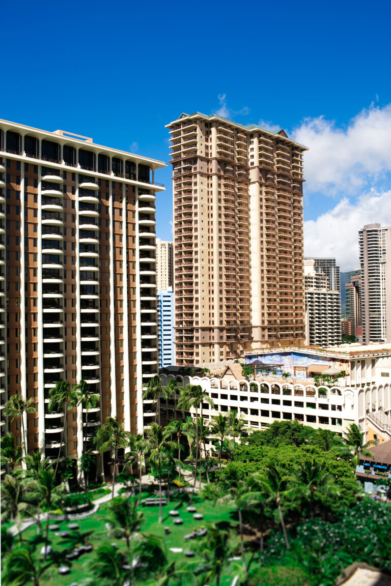 Tall brown skyscrapers and green palms before them