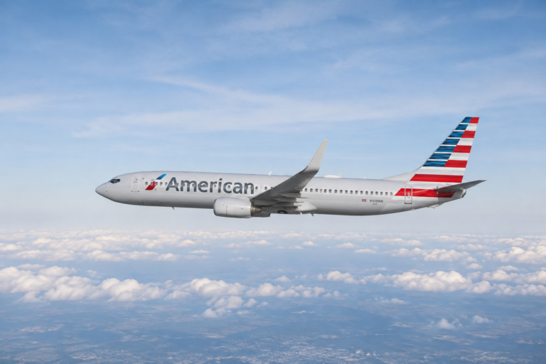 American Airlines airplane flying through a bright blue sky, representing online flight booking, affordable airfare, and convenient travel planning.